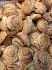 Close-up shot of a pile of freshly baked, golden-brown, and flaky pastries, ready to eat.