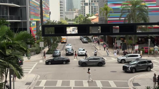 Miami, FL, USA, June 27, 2025: Car movement at the intersection of Brickell Plaza with S Miami Ave from the Brickell City Centre, Brickell Heights and SLS Lux rainbow stripped mural in background.
