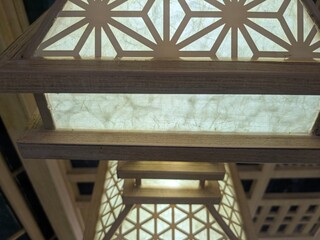 Close-up view of a Japanese-style lantern with intricate geometric patterns illuminated from within.
