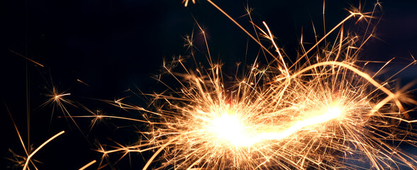 A sparkler is a type of hand held firework that burns slowly while emitting bright, colored sparks