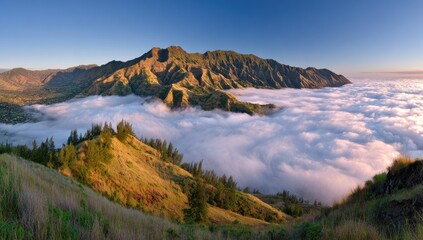 Mountain ridge above sea of clouds at sunrise with distant valley.