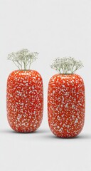 Two speckled orange vases hold delicate white flowers against a white background.