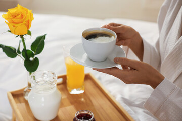 Woman having delicious breakfast in bed, closeup. Hotel room service