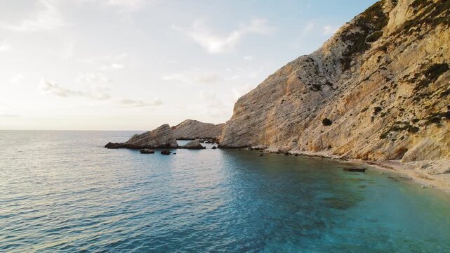 Golden cliffs meet turquoise waters on a secluded Kefalonia beach at sunset