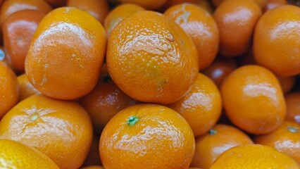 Close up pile of tasty fresh oranges sold at the market as a background.