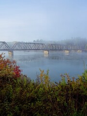  Bridge over the calm water in fog.