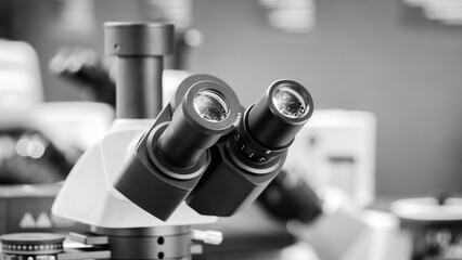 Close-up of microscope eyepieces in biological or scientific medical laboratory analysis, scientific medical concept background.