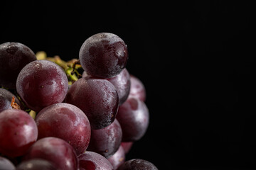 A Close-Up of Fresh Purple Grapes on a Black Background