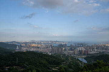 Fototapeta premium A Breathtaking Panoramic View of a Modern Cityscape Blending with Lush Mountainous Terrain