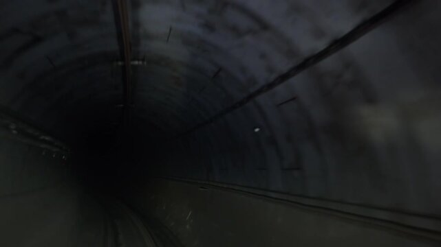 A time lapse video showing a subway train moving through a dark tunnel, symbolizing modern city transportation and underground infrastructure.
