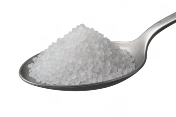 Coarse sea salt crystals filling a metal spoon