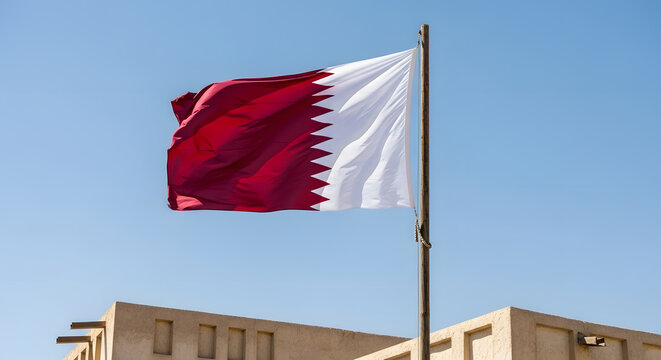 Qatar flag waving in the wind against blue sky