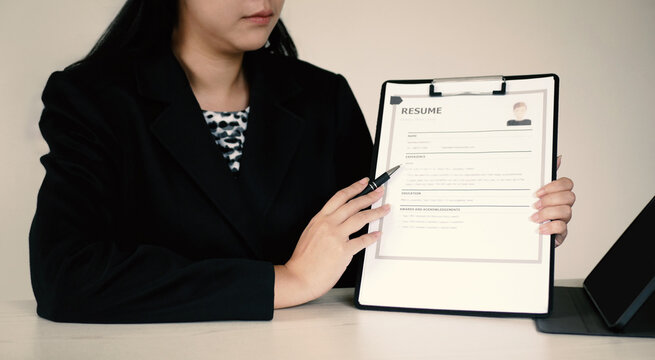 Businesswoman sits and evaluates resume and evaluates. Views resume of job applicant. Recruitment concept