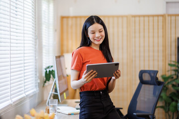 Business a young woman analyzing financial data on digital tablet during at workplace office
