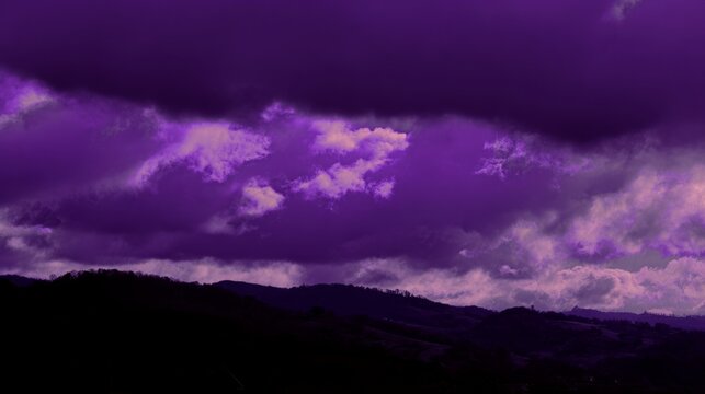 midgard. Dark purple storm clouds gathering before rainfall, dramatic sky formation, natural weather phenomenon. travel magazines, destination branding, designed for travel destination branding.