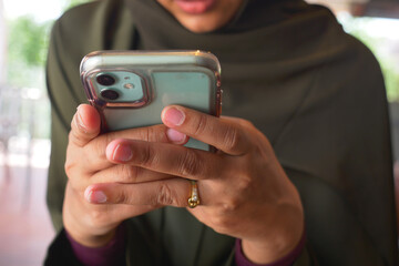 Woman using smartphone in casual setting with stylish outfit