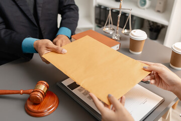 A lawyer and a client exchange a brown envelope across a desk, symbolizing confidential legal...