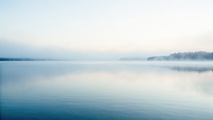 Fototapeta premium Serene water landscape with misty reflections, creating a tranquil atmosphere at dawn.
