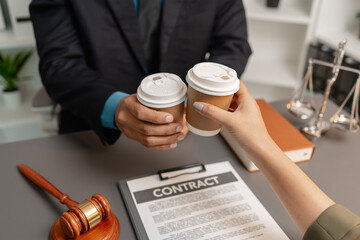 A lawyer and a client celebrate the successful completion of a legal agreement with a coffee toast...