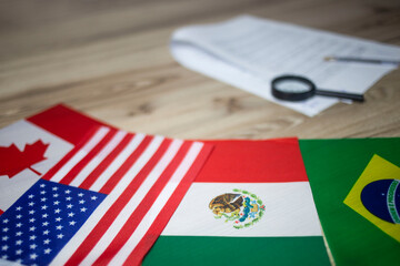 Brazil, United States, Canada and Mexico flags with documents in the office desk