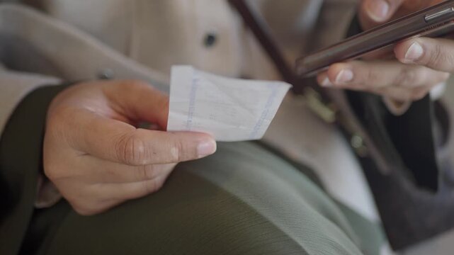 Checking receipt while using phone in a cafe