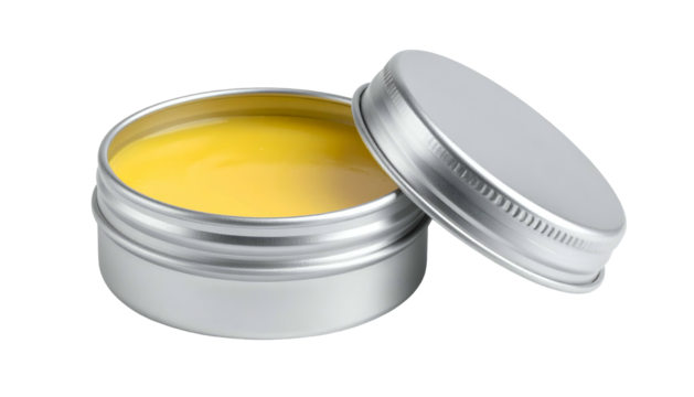 Open silver tin filled with yellow salve; lid to side, against dark backdrop