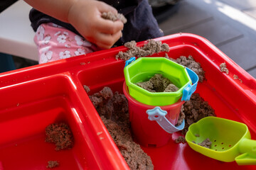 Child Enjoys Playing in Sandbox With Colorful Toys on Sunny Afternoon