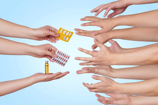 Group of human hands with pills and ampoule on blue background