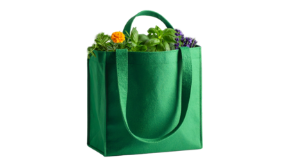 A green reusable bag brimming with vibrant green and colorful herbs, isolated on black