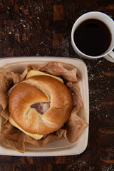 Breakfast Bagel Sandwich with Coffee on a Wooden Board