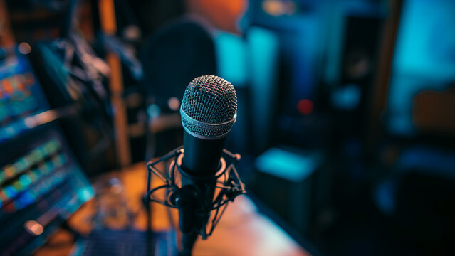 Professional studio microphone with blue lighting and blurred background - Powered by Adobe