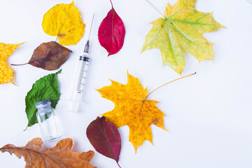Autumn vaccination of population. Syringe in autumn leaves. Vaccination in autumn. New vaccine..