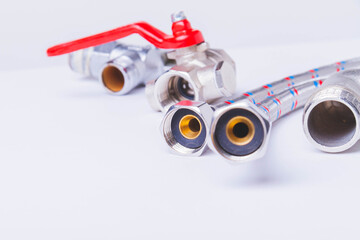 A water tap and a hose in a metal braid. Accessories for the repair of water supply..