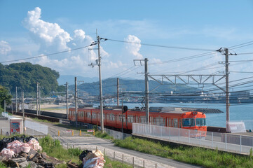 Orange Iyotetsu Train at the seaside station, Baishinji Station, Matsuyama, Ehime, Shikoku, Japan
