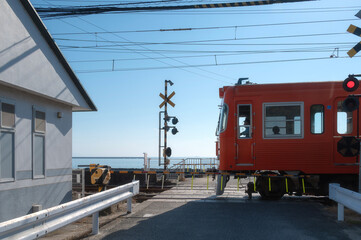 Orange Iyotetsu Train at the seaside station, Baishinji Station, Matsuyama, Ehime, Shikoku, Japan