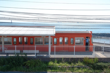 Orange Iyotetsu Train at the seaside station, Baishinji Station, Matsuyama, Ehime, Shikoku, Japan