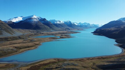 Obraz premium Stunning turquoise lake nestled between snowy mountains