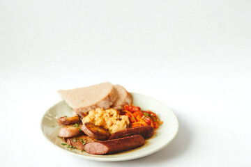 Hearty plate of sausage beans and bread on a white background