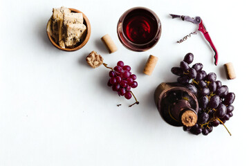 Wine and grapes with nuts and corkscrew on white background