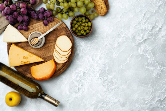 Gourmet cheese board with grapes wine and honey
