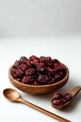 Wooden bowl filled with dried cranberries and a wooden spoon