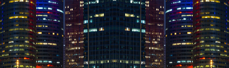 Multi-stories office building at night with worker working overtime. late night at office. lighting and working people within