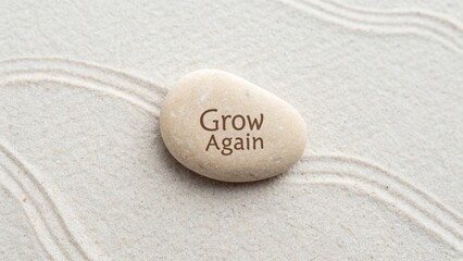 Inspirational Stone on Tranquil Sand Background with the Words Grow Again for Motivation and Reflection