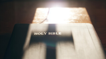 Sacred Texts: An illuminated bible is resting on a wooden surface, casting a cross-shaped shadow. The scene evokes a sense of peace and contemplation.