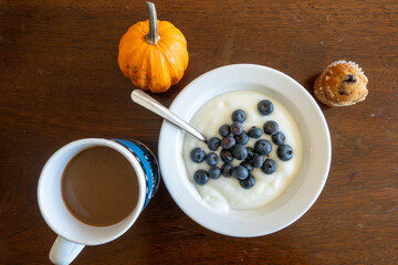 Solomons, Maryland A bowl of yogurt with blueberrries, a muffin, a cup of coffee and a pumpkin.