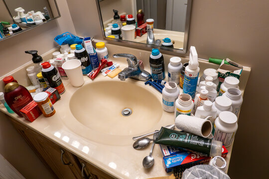 Prince Frederick, Maryland USA A messy bathroom sink crowded with medication bottles and toiletries.