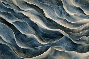 Aerial view of undulating sand dunes with flowing, rhythmic textures