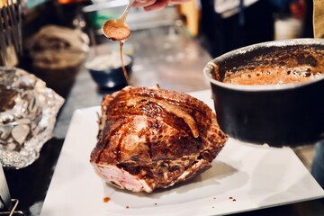 Cooking holiday dinner with baked turkey and sauce. Thanksgiving or Christmas in cozy indoor evening setting warm festive atmosphere. Restaurant cooking process