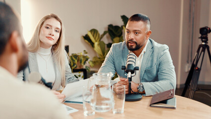 Podcast, microphone and group of people in studio for financial talk show, radio or live streaming. Investment podcaster, recording audio or host with guests for interview or broadcast with paperwork