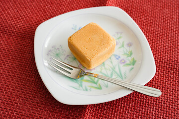 四角いカステラ風和菓子を白い皿にのせて